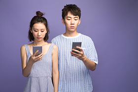 各自玩手机的青年情侣照片