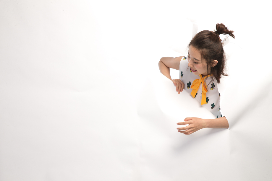 青年女人通过纸洞窥视