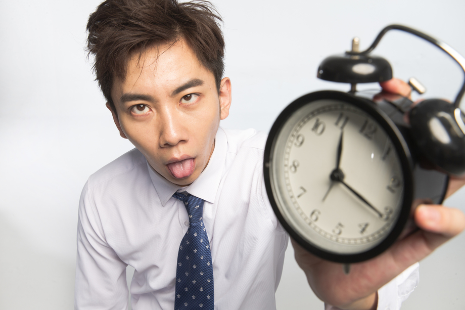 商务青年男人拿着闹钟 商务青年男人拿着闹钟