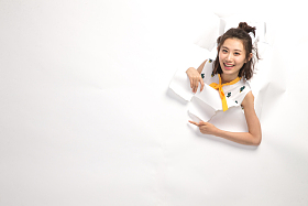 青年女人通过纸洞窥视