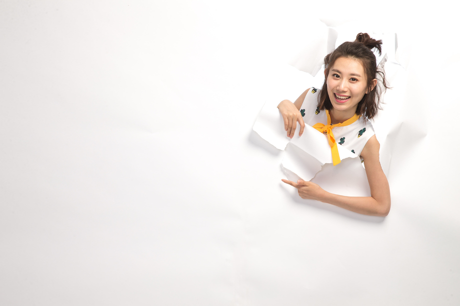 青年女人通过纸洞窥视