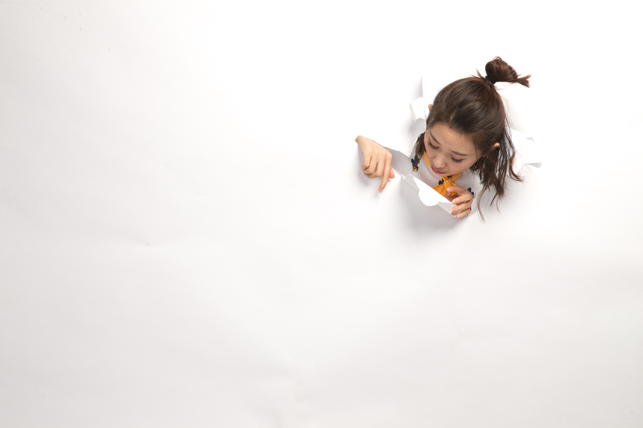 青年女人通过纸洞窥视 青年女人通过纸洞窥视