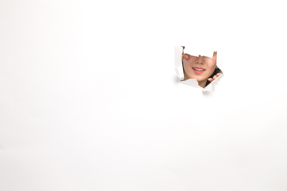 青年女人通过纸洞窥视