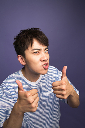 翘起大拇指的青年男人图片