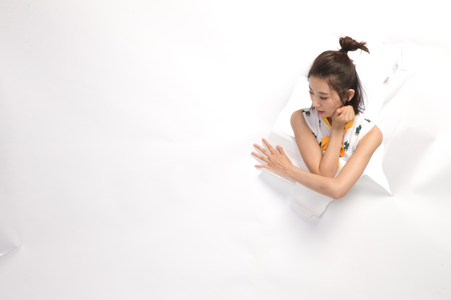 青年女人通过纸洞窥视
