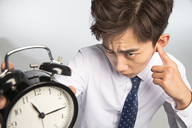 商务青年男人拿着闹钟