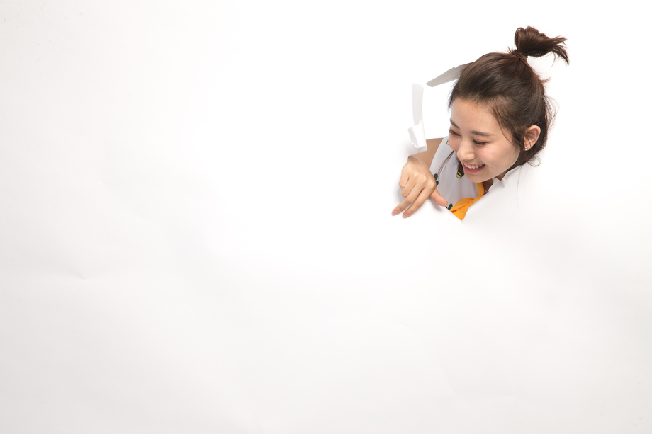 青年女人通过纸洞窥视