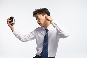 商务青年男人拿着闹钟