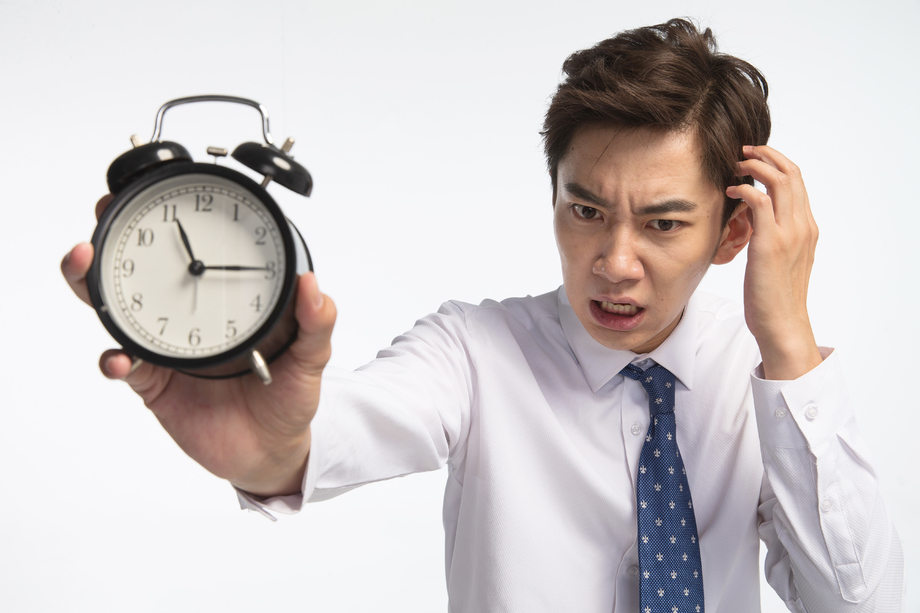 商务青年男人拿着闹钟