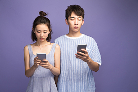 各自玩手机的青年情侣图片