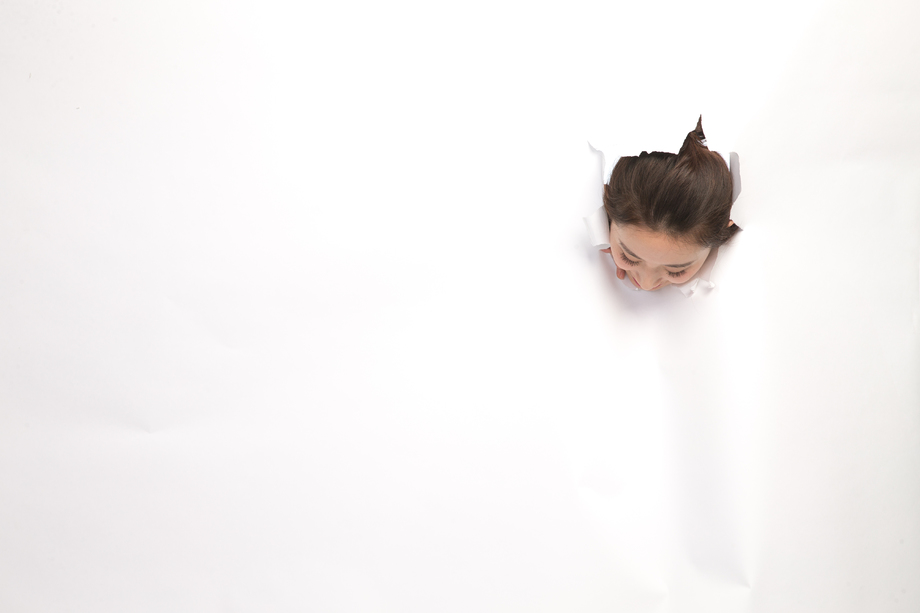 青年女人通过纸洞窥视照片