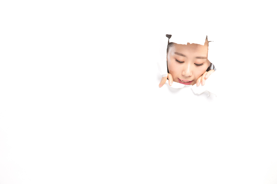 青年女人通过纸洞窥视