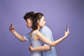 各自玩手机的青年情侣照片