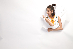 青年女人通过纸洞窥视照片