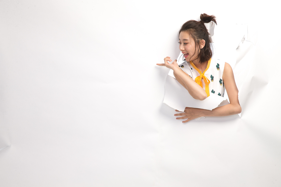 青年女人通过纸洞窥视照片 青年女人通过纸洞窥视照片