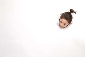 青年女人通过纸洞窥视照片