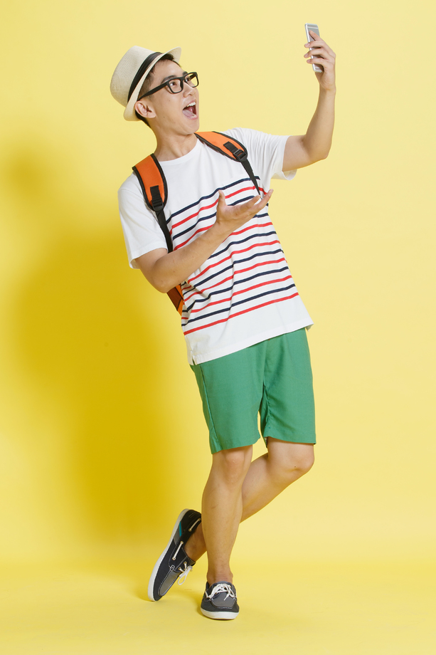 青年男人使用手机拍照图片
