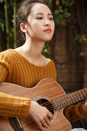 年轻女人弹吉他照片