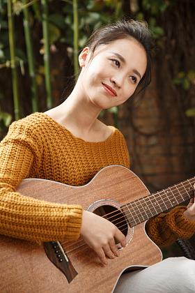 年轻女人弹吉他照片