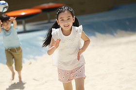 儿童在沙子里踢球照片