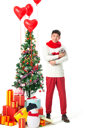 抱着宠物狗的青年男人过圣诞