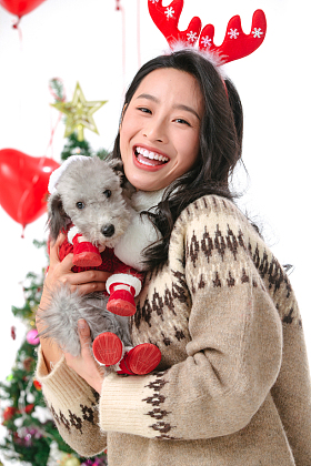 抱着宠物狗的青年女人过圣诞