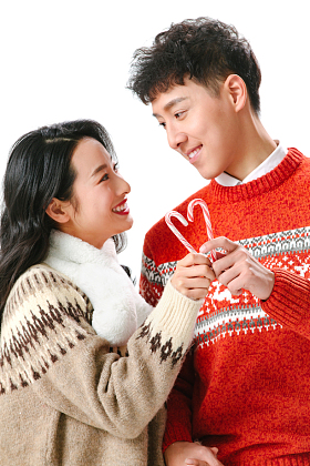 快乐的青年情侣拿着拐杖糖