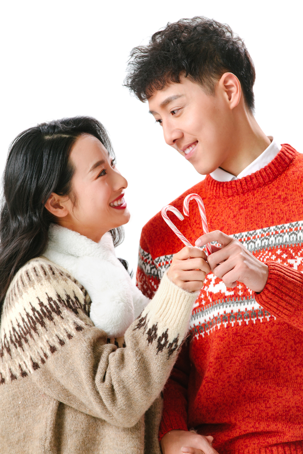 快乐的青年情侣拿着拐杖糖 快乐的青年情侣拿着拐杖糖