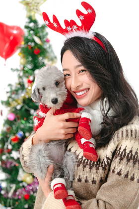抱着宠物狗的青年女人过圣诞