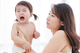 年轻妈妈抱着哭着的宝宝图片