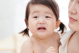 年轻妈妈抱着哭着的宝宝图片