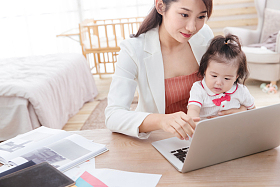 年轻妈妈抱着孩子使用电脑