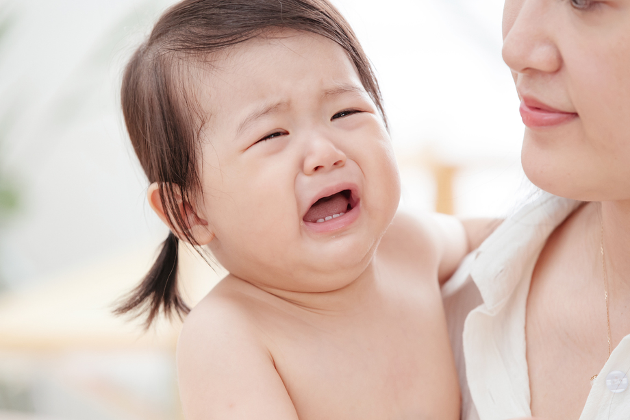 年轻妈妈抱着哭着的宝宝 年轻妈妈抱着哭着的宝宝