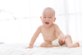 快乐宝宝坐在床上玩耍