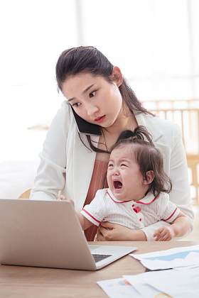 年轻妈妈抱着孩子使用电脑图片