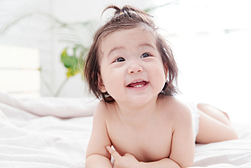 快乐宝宝趴在床上玩耍