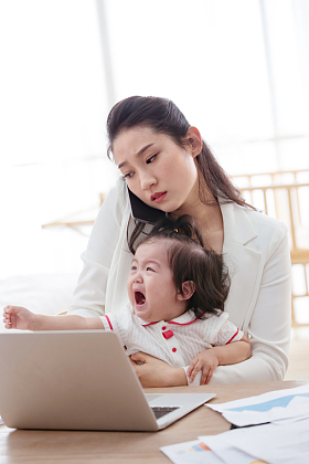 年轻妈妈抱着孩子使用电脑图片