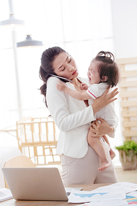 年轻妈妈抱着孩子打电话