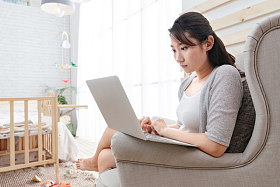 青年女人坐在沙发上使用笔记本电脑