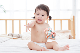宝宝坐在床上玩耍照片