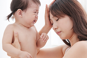 年轻妈妈抱着哭着的宝宝