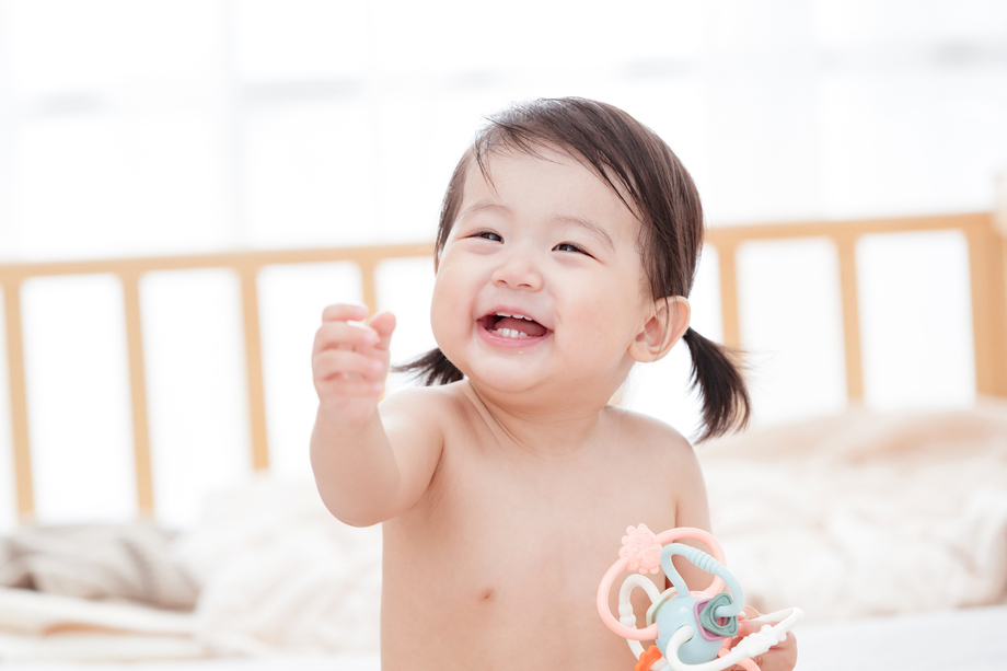 宝宝坐在床上玩耍照片