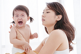 年轻妈妈抱着哭着的宝宝