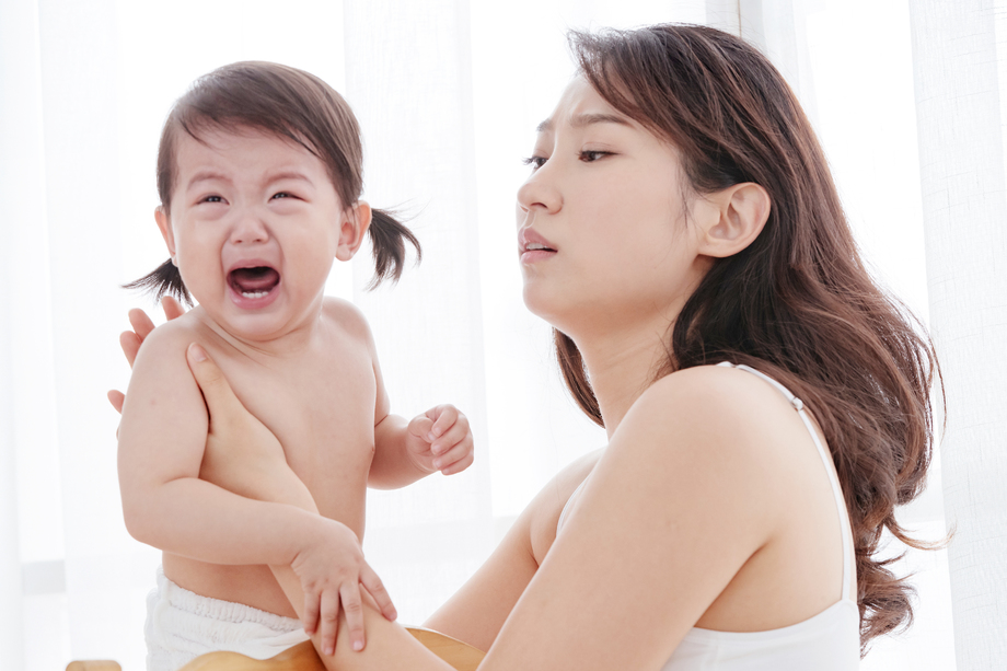 年轻妈妈抱着哭着的宝宝 年轻妈妈抱着哭着的宝宝