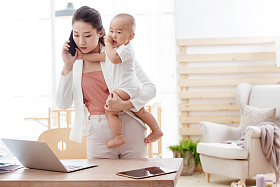 年轻妈妈抱着孩子在家办公
