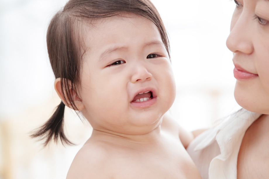 年轻妈妈抱着哭着的宝宝图片