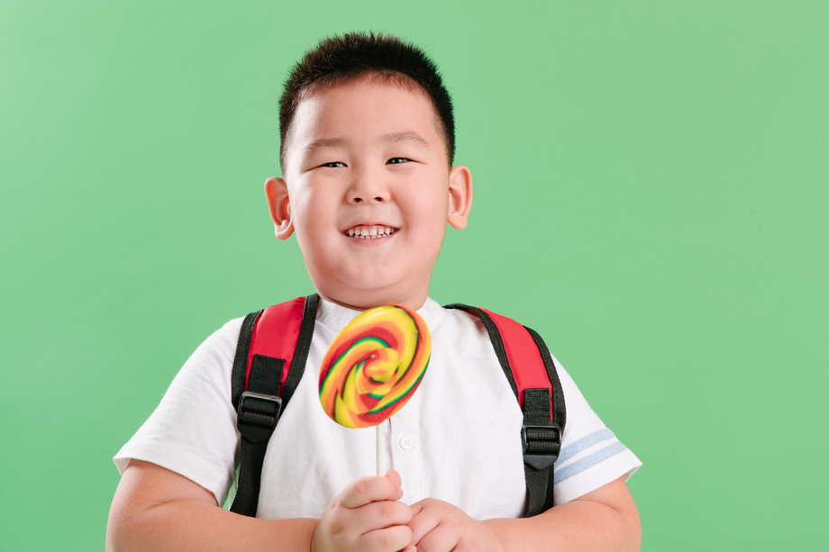 可爱的小男孩拿着棒棒糖照片