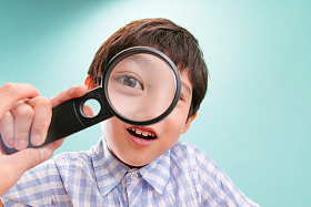 小男孩拿着放大镜