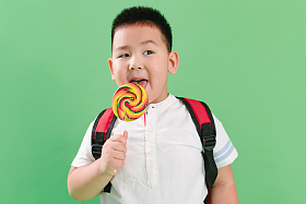 可爱的小男孩拿着棒棒糖