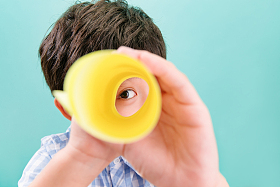 可爱的小男孩用纸质望远镜